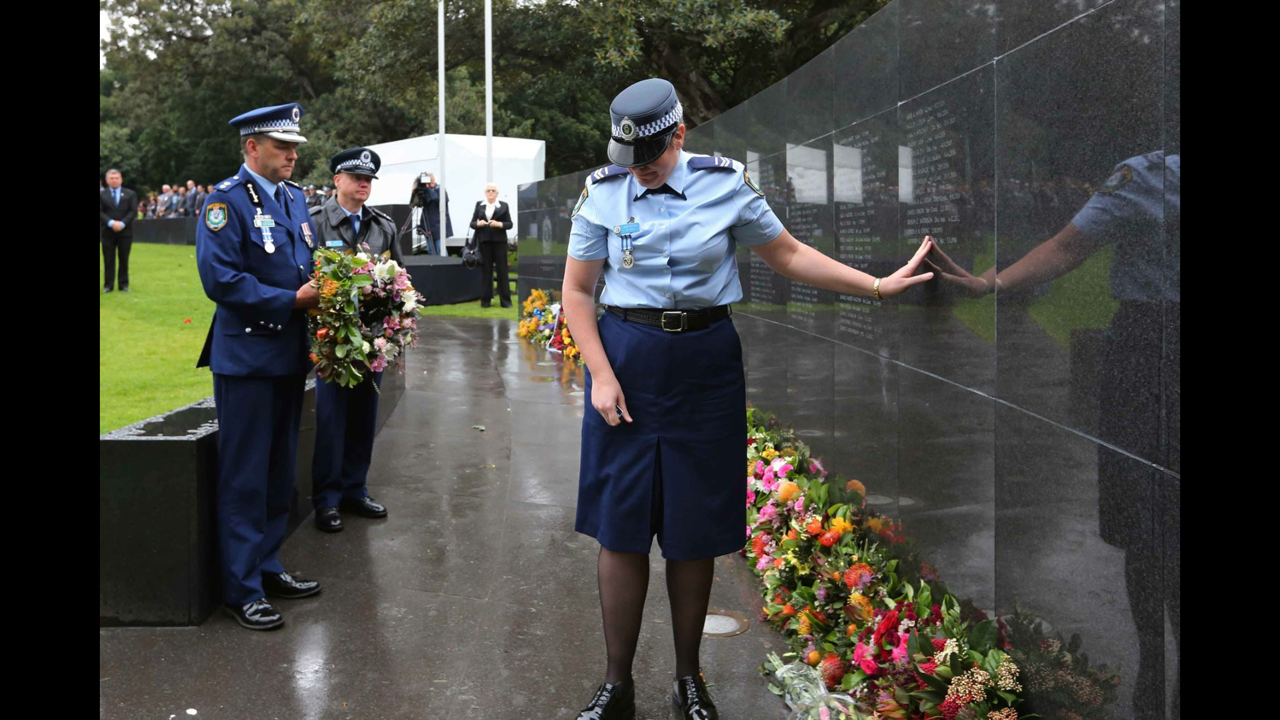 Margi,  widow of Geoffrey Richardson, places her hand on her husband’s name on the Police Wall of Remembrance. 