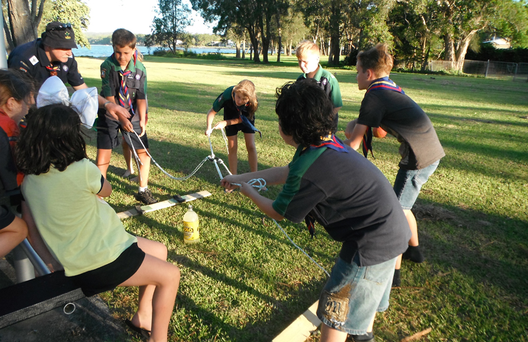 Scouts working together on a teamwork brainstorming activity to solve a problem.